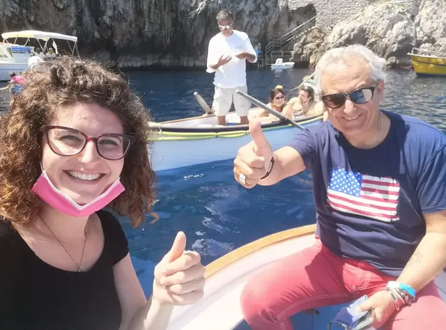 Guests on a boat at the entrance to the Blue Grotto