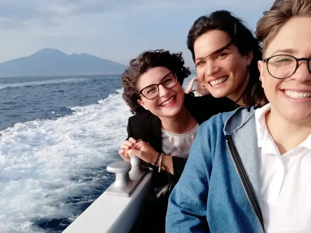 Three friends on the boat in the Gulf of Naples, Vesuvius behind them