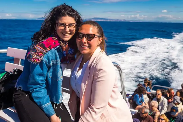 Two friends on the boat with the wake behind them